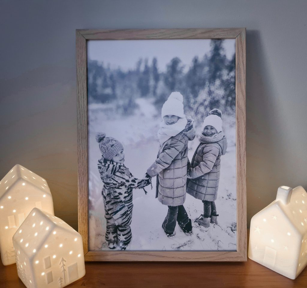 Tavla med bild på tre barn i skogen.